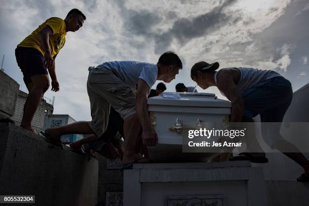 Family and friends carry the coffin of Joel Marasigan on June 27, 2017 in Manila, Philippines. Marasigan, a father of four, was shot and killed by...