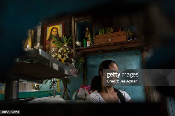 Lilly Padilla is seen through a hole on their door during her husband's wake on June 30, 2017 in Quezon city, Philippines. Lilly's common-law...