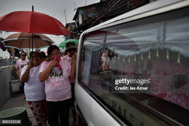 Family and friends of Nercy Galicio walking by the hearse of the funeral on April 30, 2017 in Navotas, Philippines. Nercy was reportedly abducted by...