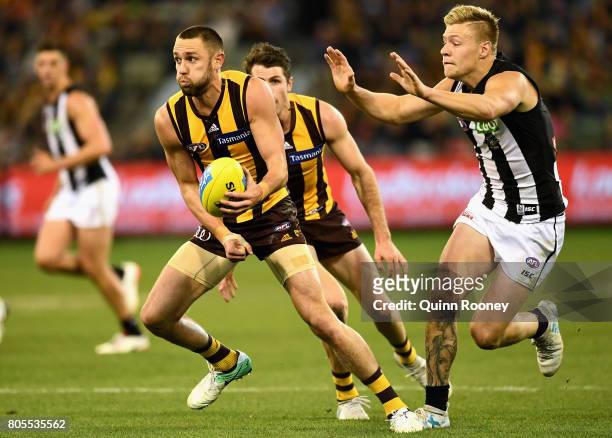 Jack Gunston of the Hawks handballs during the round 15 AFL match between the Hawthorn Hawks and the Collingwood Magpies at Melbourne Cricket Ground...