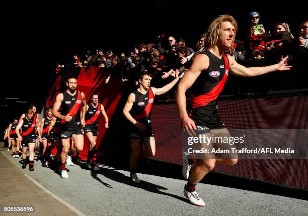 Dyson Heppell of the Bombers leads the team onto the field during the 2017 AFL round 15 match between the Essendon Bombers and the Brisbane Lions at...