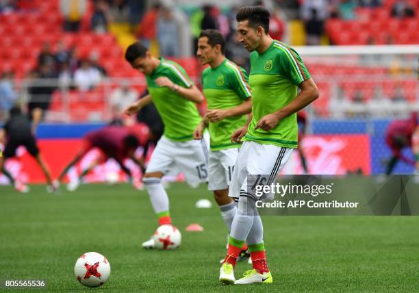 Mexico's midfielder Hector Herrera warms up with teammates ahead of the 2017 FIFA Confederations Cup third place football match between Portugal and...