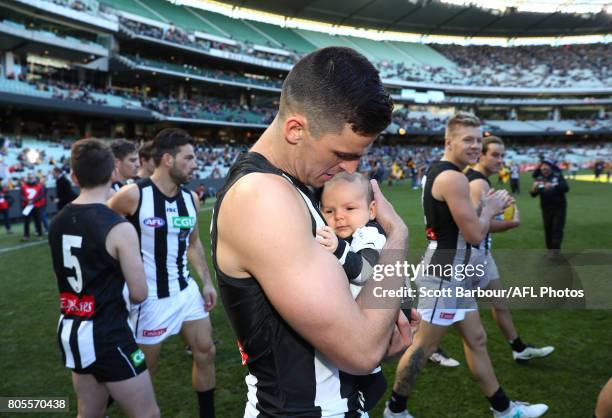 Scott Pendlebury of the Magpies walks out with his son Jax for his 250th match during the round 15 AFL match between the Hawthorn Hawks and the...