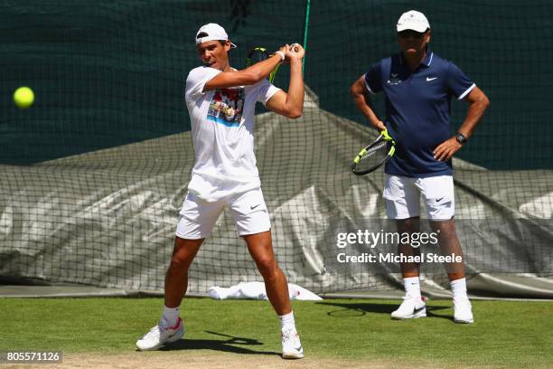 Rafael Nadal of Spain is watched closely by coach Toni Nadal during a practise session at Wimbledon on July 2, 2017 in London, England.