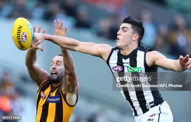 Jack Gunston of the Hawks and Brayden Maynard of the Magpies compete for the ball during the round 15 AFL match between the Hawthorn Hawks and the...