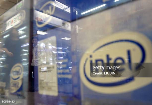 Shopkeepers are reflected on a counter as the Intel products displayed inside at a comupter market in Beijing, on April 08, 2008. The global...