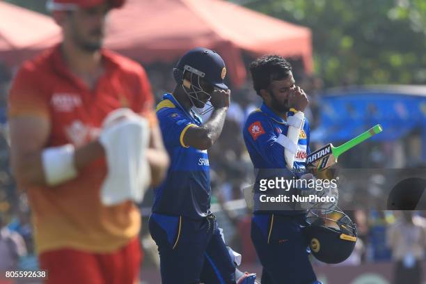 Sri Lankan cricket captain Angelo Mathews and Upul Tharanga walk back to pavilion after securing a win during the 2nd One Day International cricket...