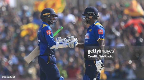 Sri Lankan cricket captain Angelo Mathews and Upul Tharanga congratulate each other after securing the victory during the 2nd One Day International...