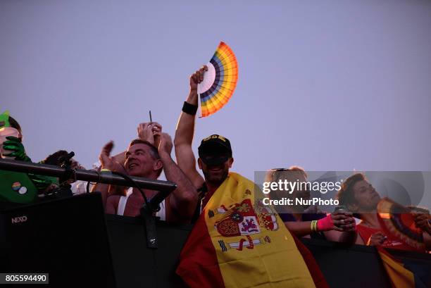 Participant whith a spanish flag on a open truck during the Gay Pride demonstration and parade in Madrid on July 1st, 2017.