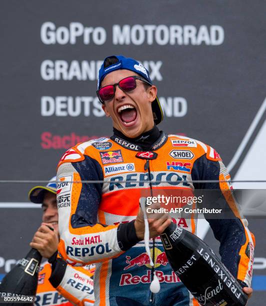Repsol Honda Team's Spanish rider Marc Marquez sprays with champagne on the podium after winning the MotoGP competition of the Moto Grand Prix of...