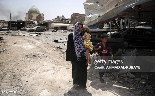 Iraqis flee from the Old City of Mosul, with the destroyed Al-Nuri Mosque seen in the background, on July 2 as Iraqi government forces continue their...