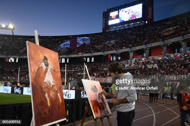 An artist paints a portrait of Fernando Cavenaghi during Fernando Cavenaghi's farewell match at Monumental Stadium on July 01, 2017 in Buenos Aires,...