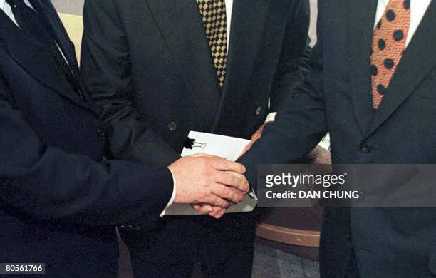 File picture of British Prime Minister Tony Blair US Senator George Mitchell and Irish Prime Minister Bertie Ahern shaking hands after they signed...