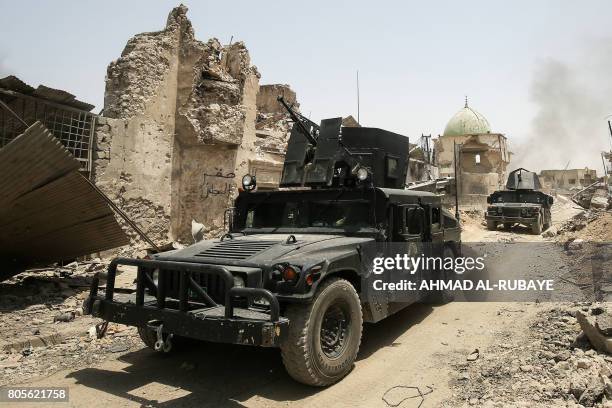 Iraqi Counter-Terrorism Service humvees drive past the destroyed Al-Nuri Mosque in the Old City of Mosul on July 2, 2017 during the Iraqi government...