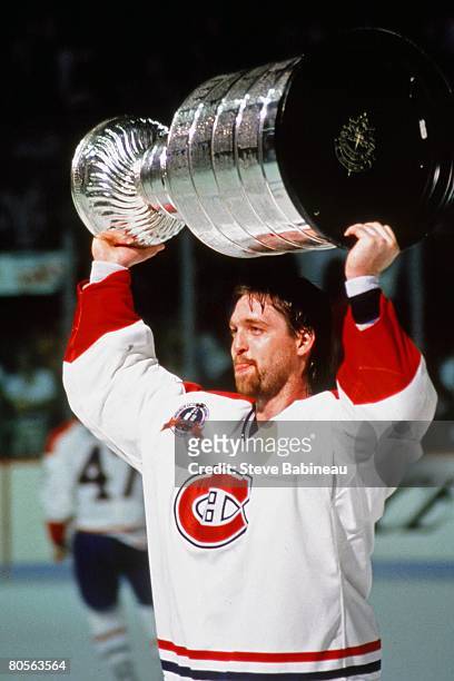 Patrick Roy of the Montreal Canadiens raises Stanley Cup in celebration after defeating the Los Angeles Kings in game at the Montreal Forum.