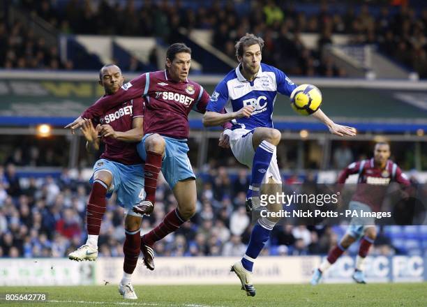 Birmingham City's Roger Johnson has a shot on goal which is blocked by West Ham United's Guillermo Franco and Daniel Gabbidon
