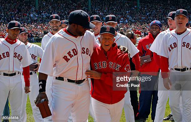 David Ortiz of the Boston Red Sox and Red Sox legend Johnny Pesky walk to center field to raise the 2007 World Series banner during pre-game...