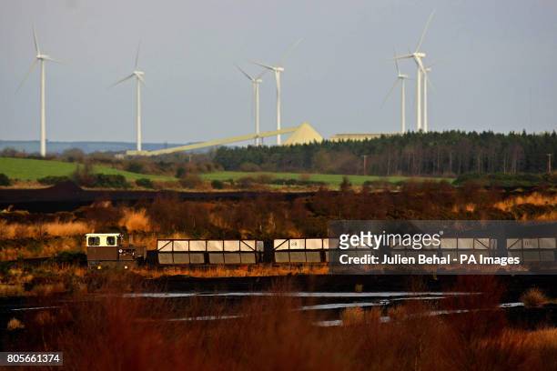 Train crossing a bog passes in front of a wind farm while carrying peat to the Bord na Mona Peat Briquettes manufacturing factory at Littleton in Co....