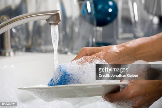 hands washing a plate - foam hand stockfoto's en -beelden