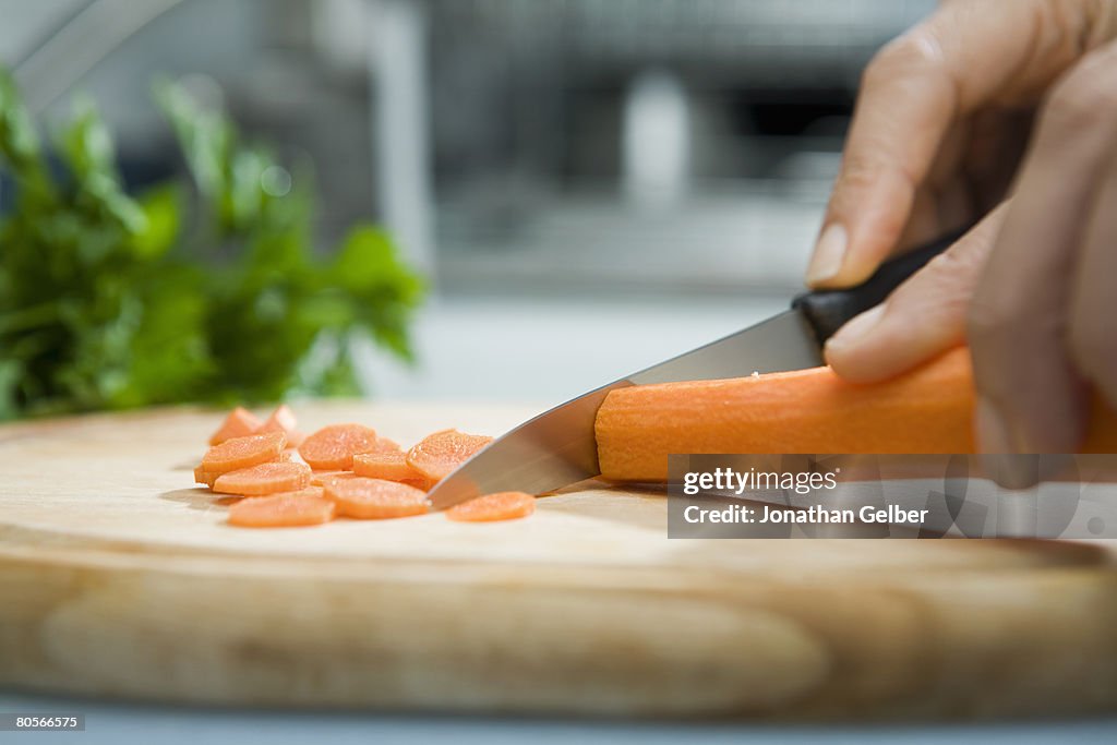Close up of hand chopping carrot