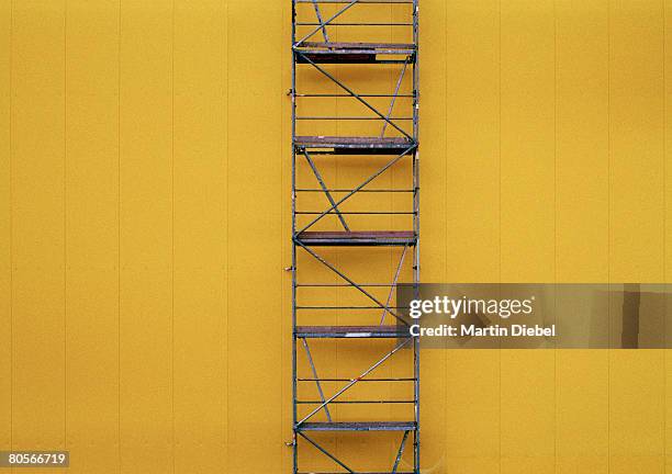 scaffolding against a yellow wall - scaffolding stock pictures, royalty-free photos & images