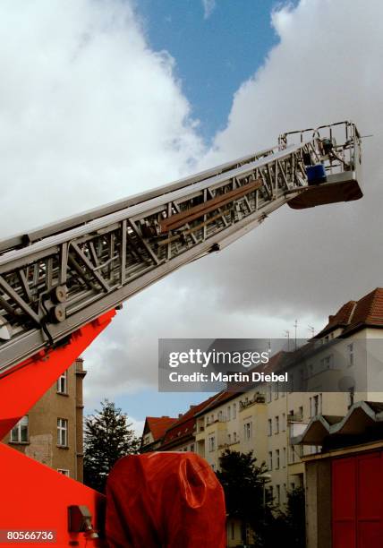 fire truck ladder extended into the sky - feuerwehr-hinweisschild stock-fotos und bilder