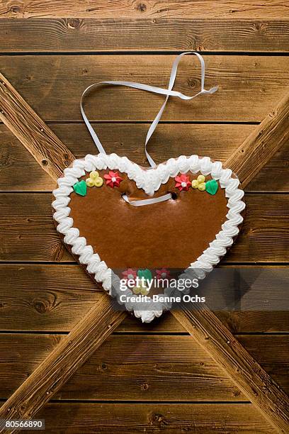 a heart shaped cookie hanging on a wooden wall - gingerbread cookie stock pictures, royalty-free photos & images