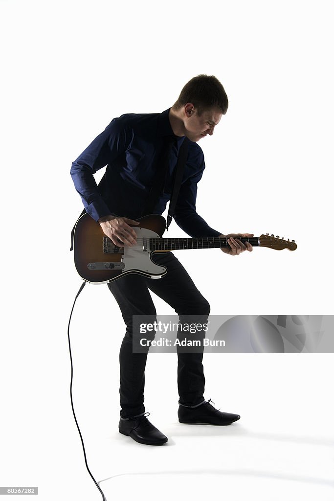 Studio shot of a man playing an electric guitar