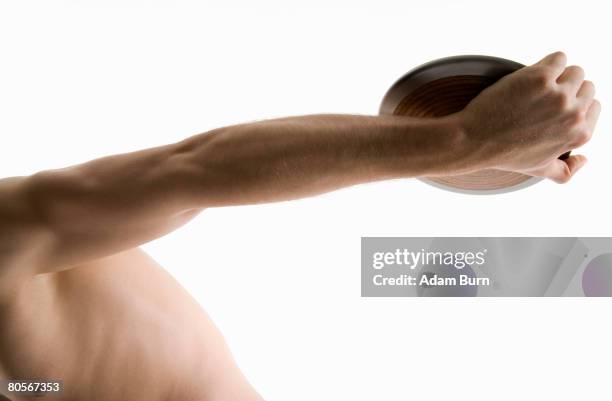 studio portrait of a male discus thrower holding a discus - discus stock pictures, royalty-free photos & images
