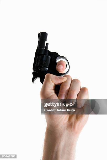 studio shot of a human hand holding a starting gun - startschot stockfoto's en -beelden