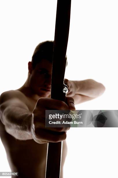 silhouette of archer pulling an arrow back on his longbow - adam bow stock pictures, royalty-free photos & images