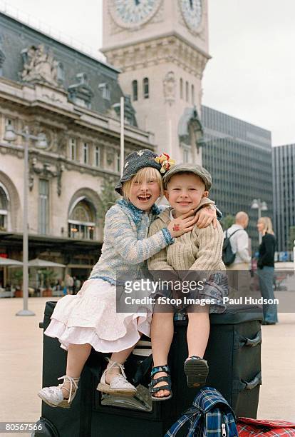 two children sitting on luggage outside the gare de lyon, paris - station de vacances 個照片及圖片檔