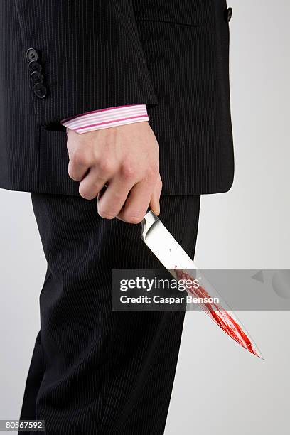 a businessman holding knife with blood on it - bloody knife stock pictures, royalty-free photos & images