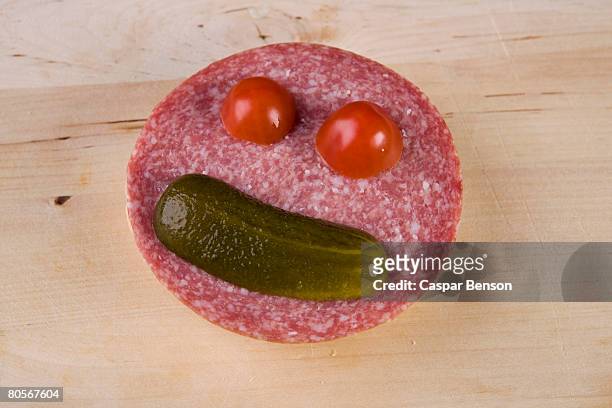 an anthropomorphic face on a slice of salami - sliced pickles stockfoto's en -beelden