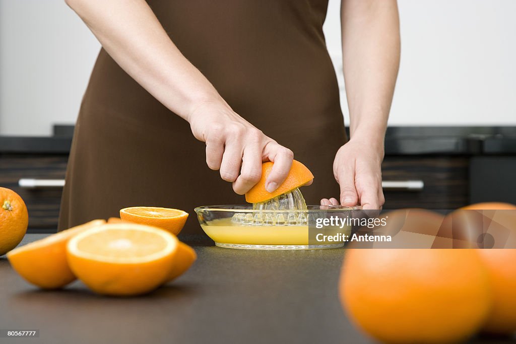 A woman juicing oranges