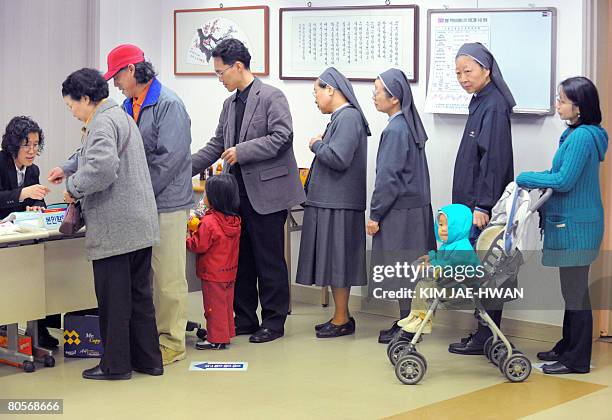 South Koreans line up to cast their ballot in the country's general election in Seoul on April 9, 2008. South Koreans went to the polls to elect a...