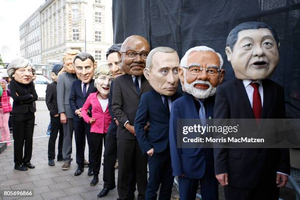 Protesters dressed like the G20-leaders return backstage from their appearance during a demonstration against the upcoming G20 economic summit during...