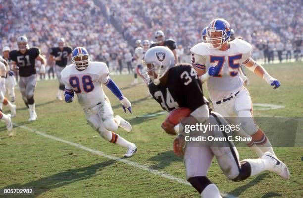 Bo Jackson of the Los Angeles Raiders rushes against the Denver Broncos at the Coliseum circa 1987 in Los Angeles,California.