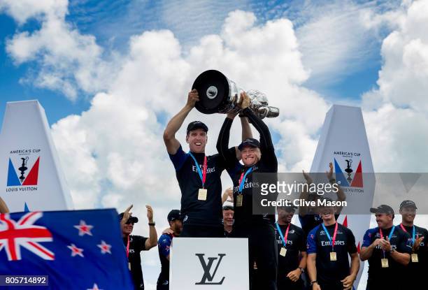 Peter Burling, Helmsman and Glenn Ashby, skipper of Emirates Team New Zealand lift the America's Cup trophy as Emirates Team New Zealand win race 9...