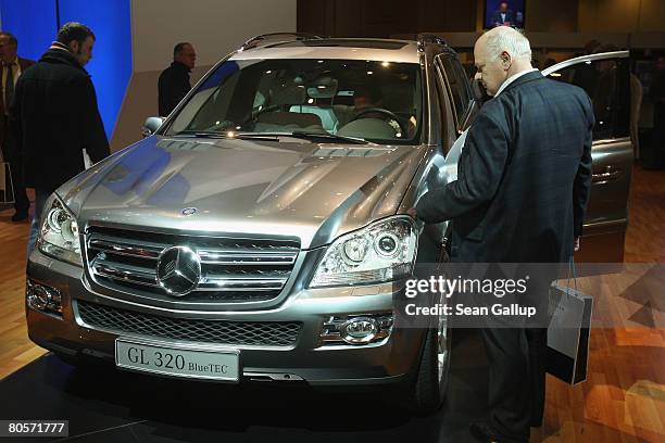 Shareholders look at a Mercedes-Benz GL 320 BlueTec mammoth SUV at the annual Daimler general shareholders' meeting on April 9, 2008 in Berlin,...