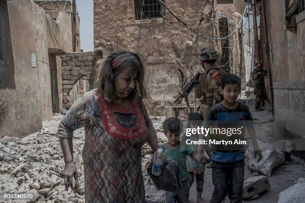 An Iraqi woman and her children flee the Old City district where heavy fighting continues on July 2, 2017 in Mosul, Iraq. Iraqi forces continue to...