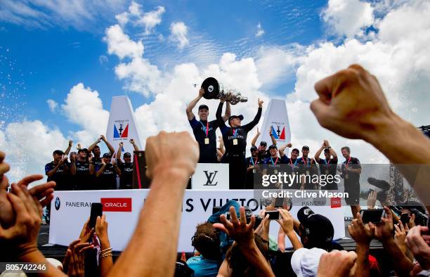 Peter Burling, Helmsman and Glenn Ashby, skipper of Emirates Team New Zealand lift the America's Cup trophy as Emirates Team New Zealand win race 9...