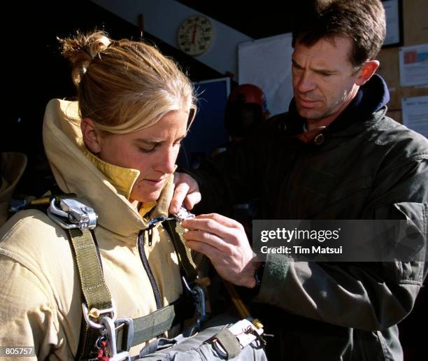 Sarah Pierce, a surfer and basketball coach from Mooro Bay, CA, has her pre-flight gear check done by Darren Bellsbee at the North Cascades...