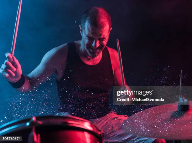 rock n roll drummer with sparkles coming off the drums - drummer stock pictures, royalty-free photos & images