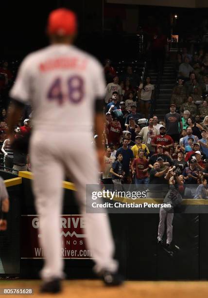 Outfielder Ian Desmond of the Colorado Rockies is unable to catch a home run ball hit by Chris Owings of the Arizona Diamondbacks during the fourth...