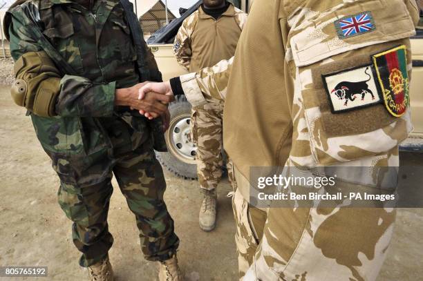 An Afghan National Army soldier shakes hands with a British Forces soldier at Camp Bastion, as they prepare to carry out a Combat Logistics Patrol ,...