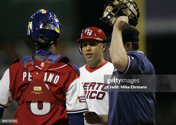 Carlos Beltran of team Puerto Rico argues with catcher Ariel Pestano about the position of the batboy during a 2nd round game against team Cuba...