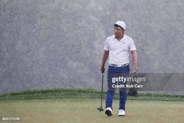 Sung Kang of Korea reacts on the 16th green in the rain during the final round of the Quicken Loans National on July 2, 2017 TPC Potomac in Potomac,...