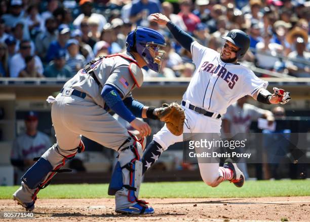 Luis Torrens of the San Diego Padres scores ahead of the throw to Yasmani Grandal of the Los Angeles Dodgers during the fiourth inning of a baseball...