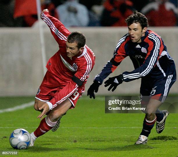 Chad Barrett of the Chicago Fire and Michael Parkhurst of the New England Revolution go for the ball during the first half at Toyota Park on April 3,...